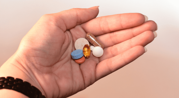 hand holding assortment of medication