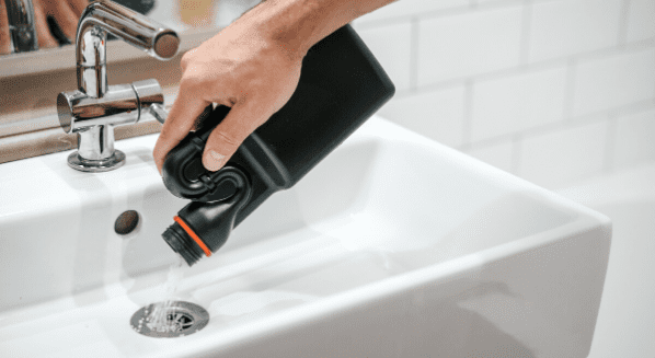 pouring drain cleaner in sink
